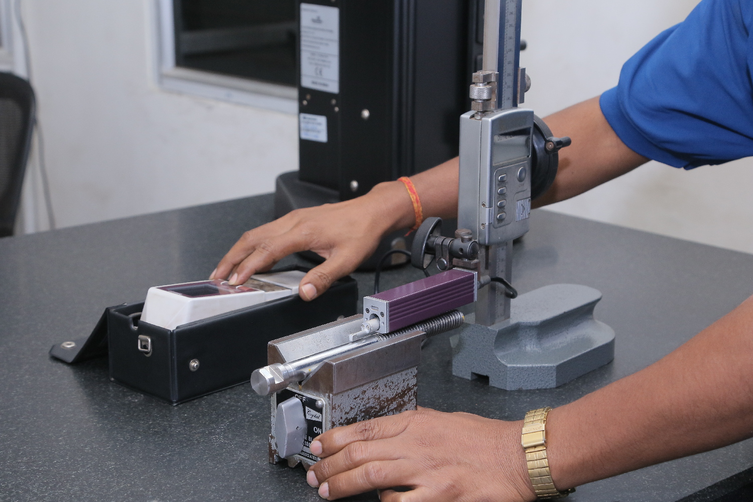 A technician operating a blue industrial machine component.